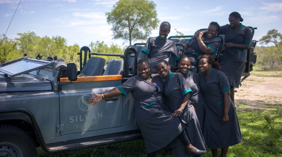 Staff Silvan, photo de groupe Staff Silvan, photo de groupe de l'équipe de Silvan Safari devant un 4x4 dans la savane lors d'un safari.
