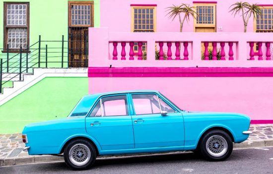 Blauer Oldtimer vor grünem und pinkem Haus im Bo-Kaap, Kapstadt