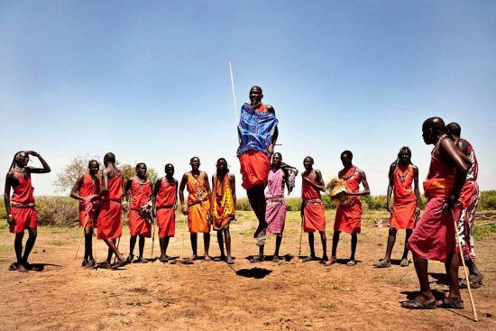 Peuple Massaï marchant dans les plaines du Masai Mara au Kenya en habits traditionnels.