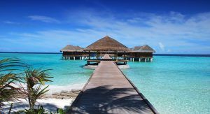 Wooden walkway leads to elevated huts over the Indian Ocean in Maldives