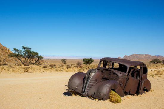 Ein altes, ausgebranntes Auto im Ghost Valley in Namibia