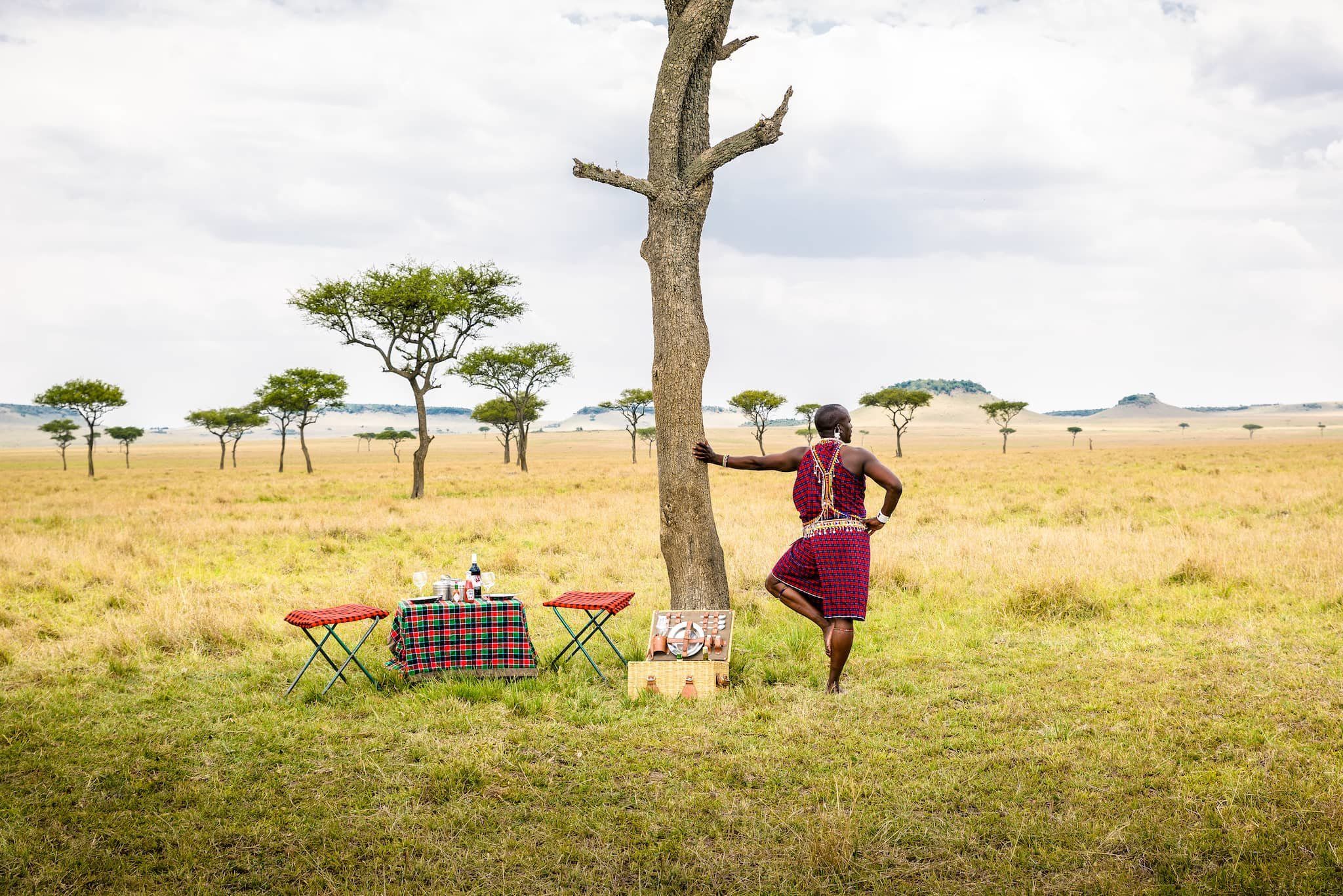 Maasai warrior leaning against a tree