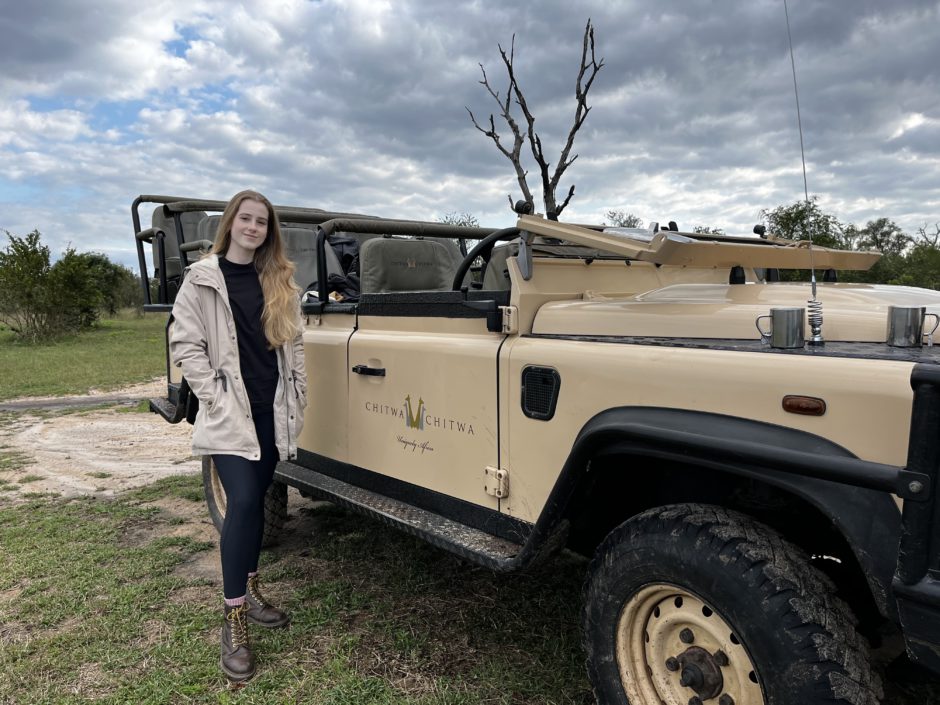 Girl standing in front of a Chitwa Chitwa game drive vehicle on safari in the Sabi Sand