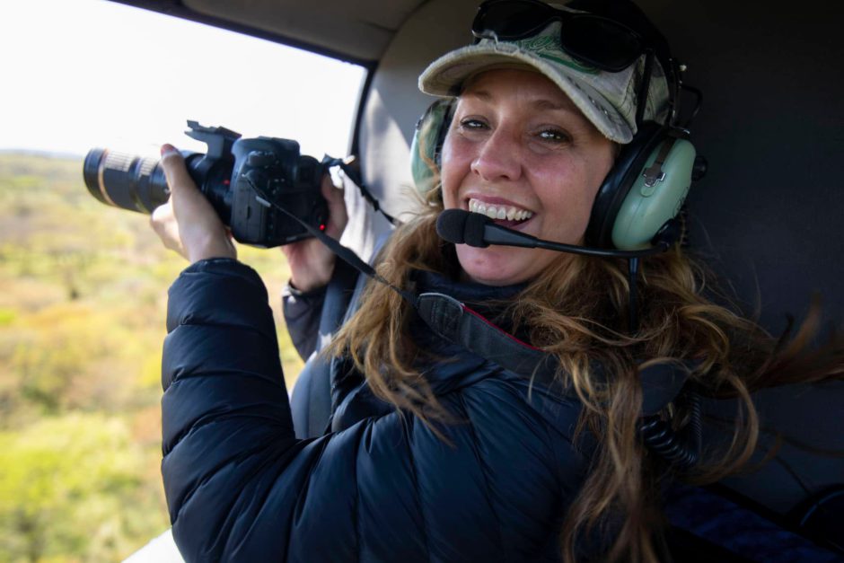 Bianca Johnstone, a Rhino Africa Travel Expert smiles mid-flight with a camera in hand, capturing the view from above