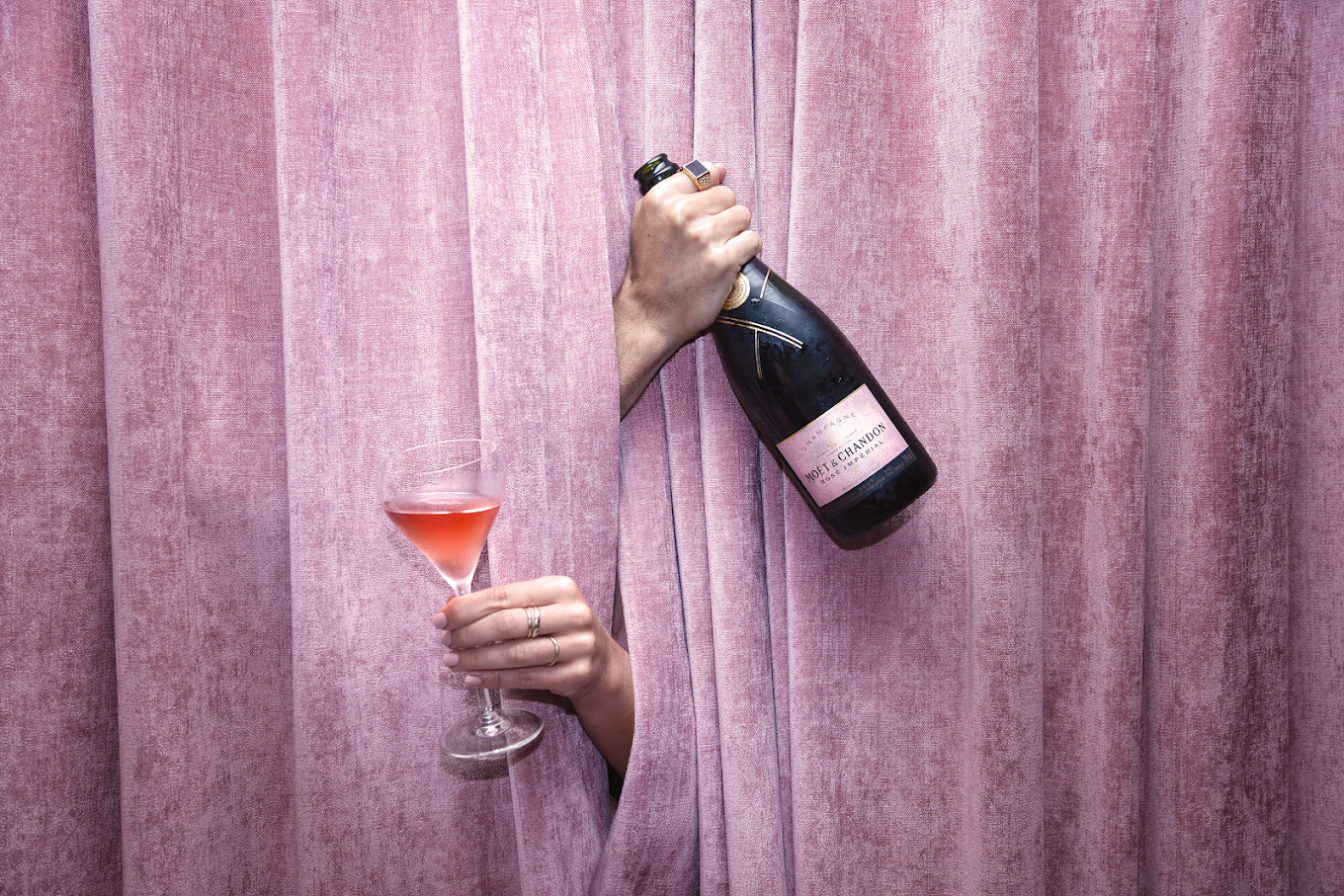 2025-01-27 A bottle and glass of Rosé Champagne in front of a velvet drape curtain