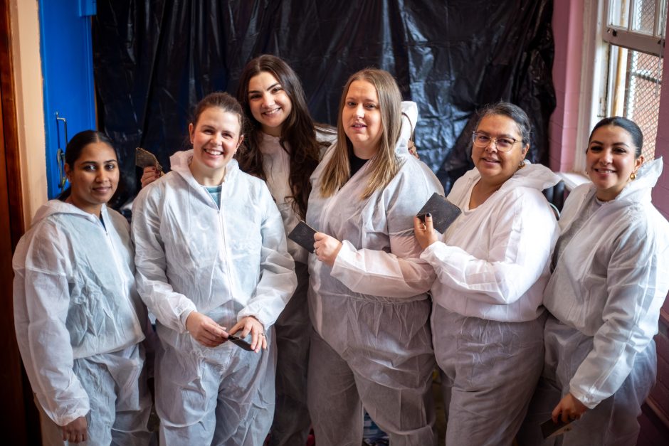 madiba-day-chapel-street-school-painting-2025-97 A group of Rhino Africa volunteers smile together during a classroom painting project on Mandela Day