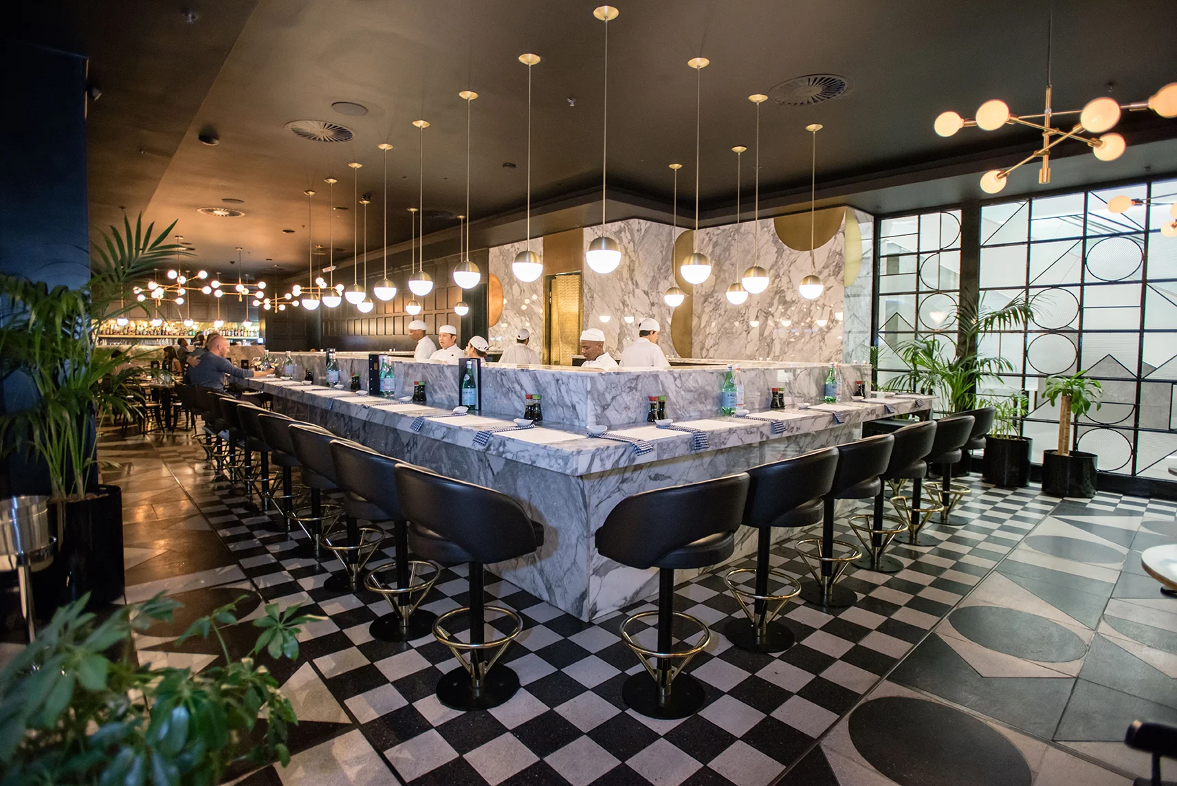 the-big-mouth A large, white marble-clad sushi bar, black steel finishes, and checkered floor tiles