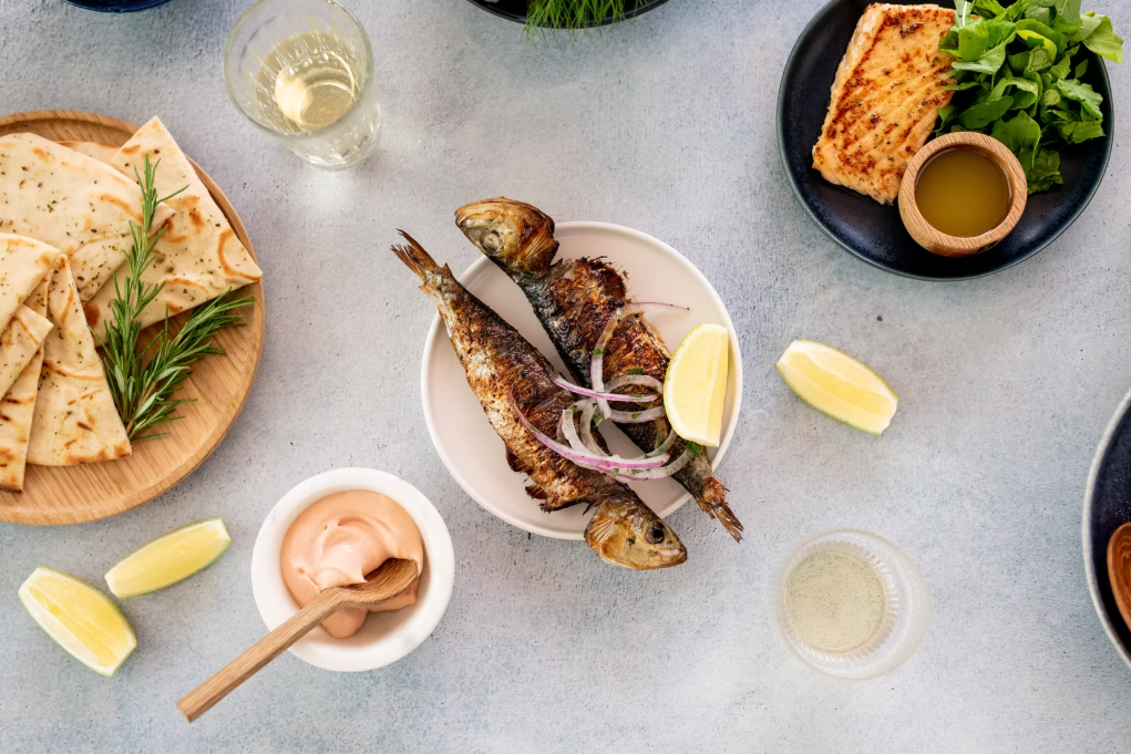 mezepoli-restaurant A table with fish and flatbread tapas with lemons and sauce