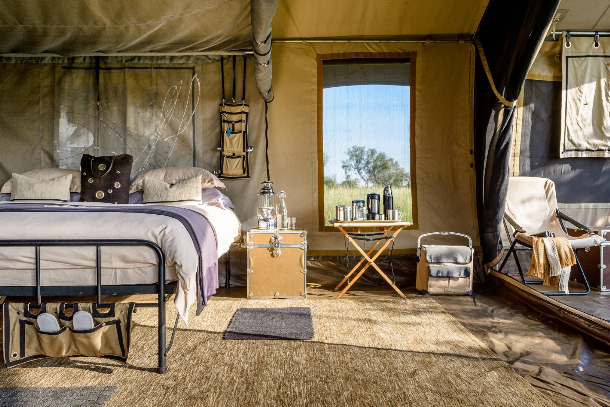 Singita-Explore-Camp-tent The interior of one of Singita’s mobile tented camps reveals a king-sized bed, canvas furnishings, and curated comforts with views into the bush.