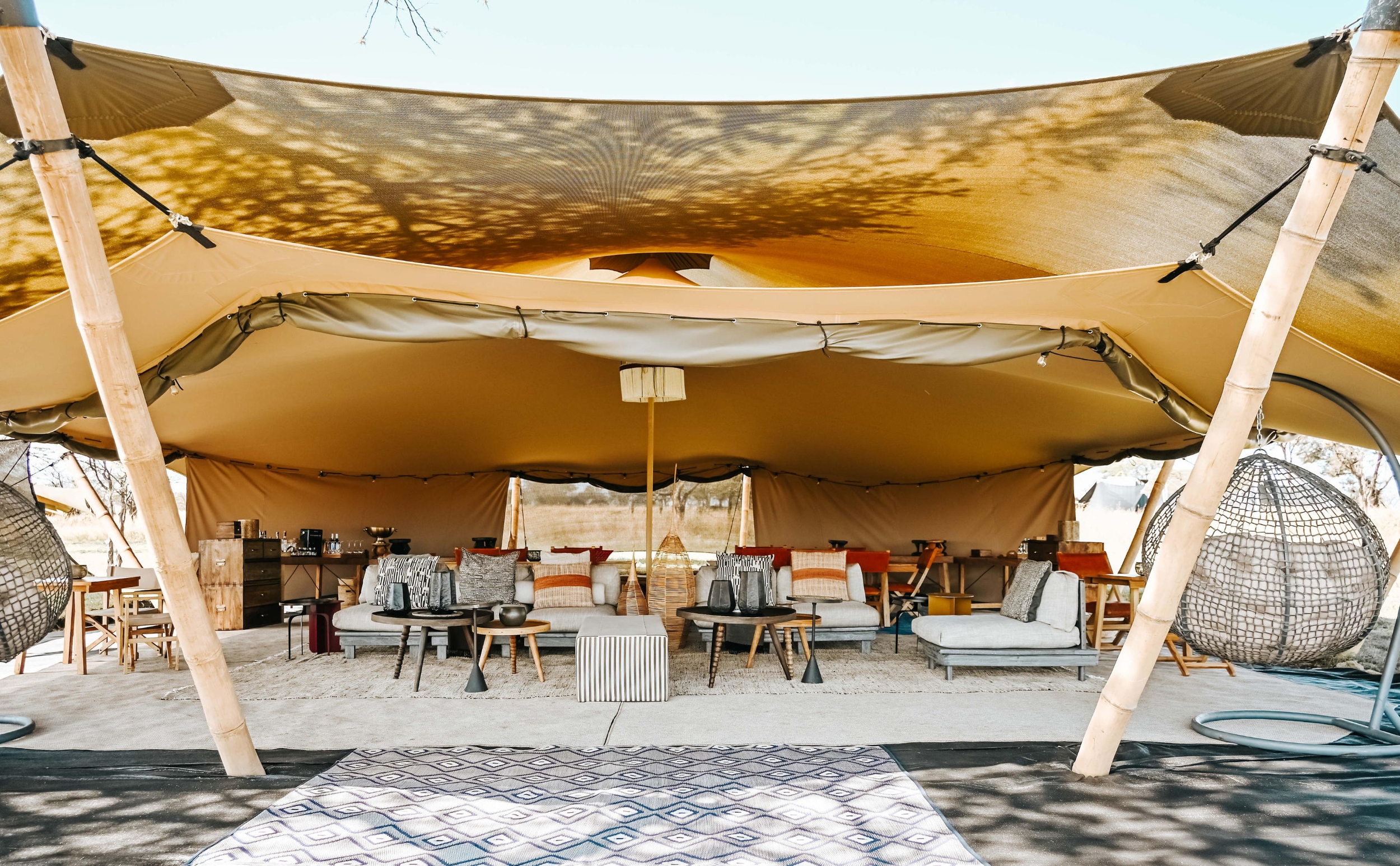 Wilderness-Usawa-Serengeti-cover A stylish open-plan lounge at one of Africa’s mobile tented camps features relaxed seating, woven textures, and a floating canopy roof.