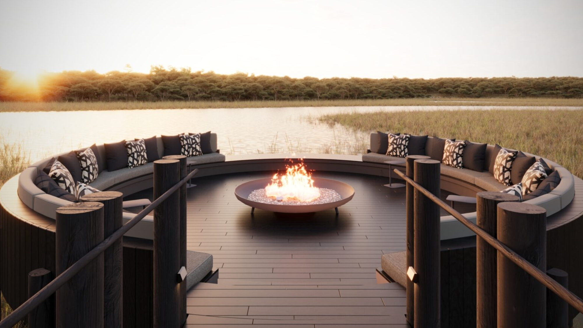 Sediba-Sa-Rona-luxury-lodges-2026-firepit A circular outdoor fire pit with curved cushioned seating overlooks the water at sunset, setting the scene for one of the new luxury safari lodges 2026.