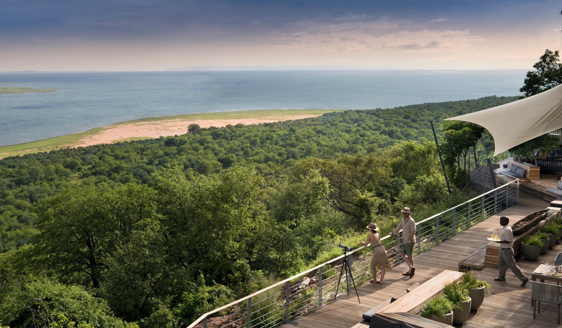 A hilltop deck overlooks dense woodland and Lake Kariba, grounding a striking sense of place in where to go in 2026.