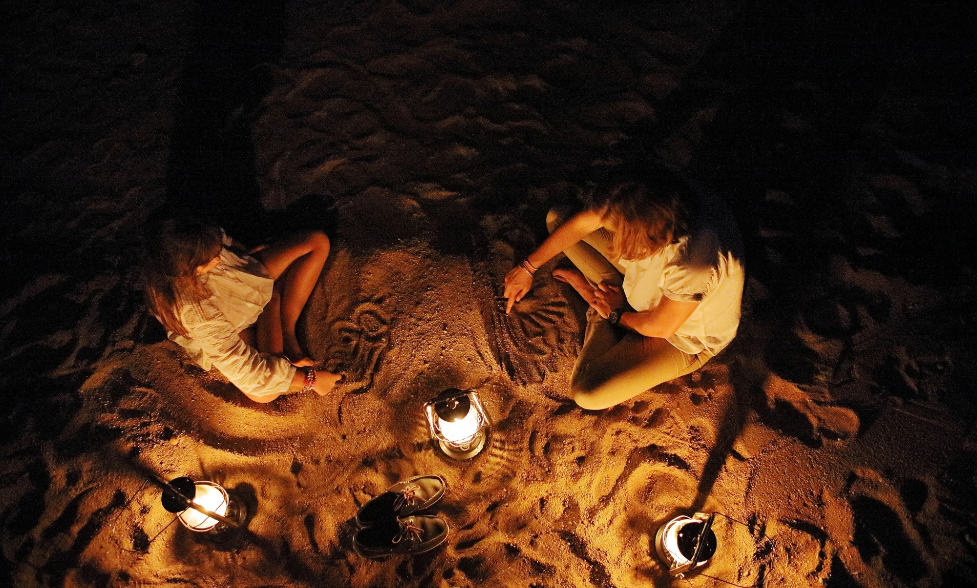 A mother and child play in the sand at Londolozi