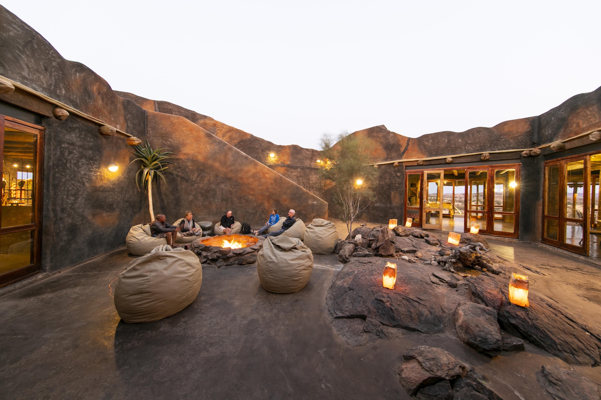 Wilderness Doro Nawas Guests enjoy a camp fire in the courtyard of one of the best luxury lodges in Namibia