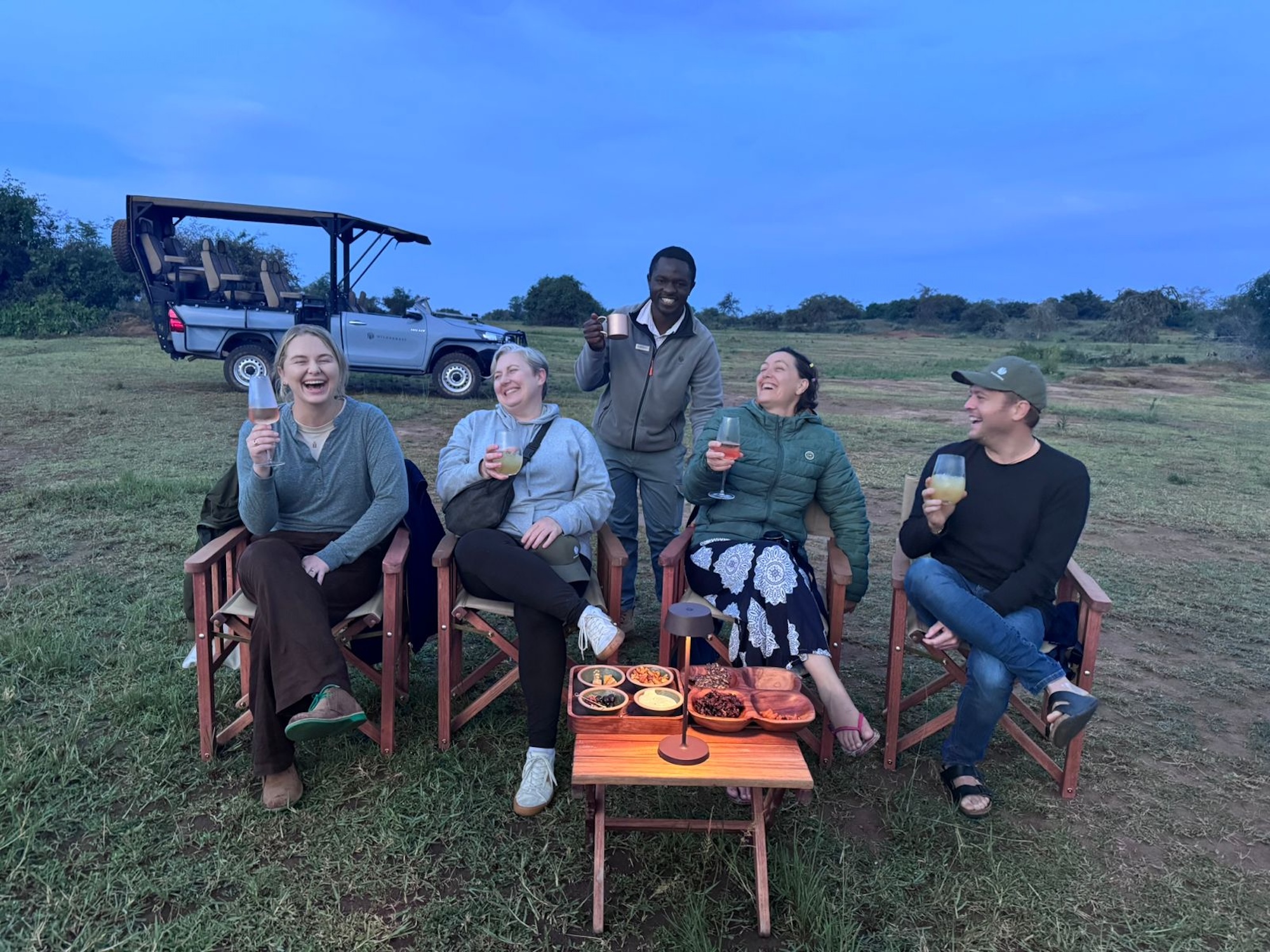 Five people enjoying sundowners on a Rwanda safari