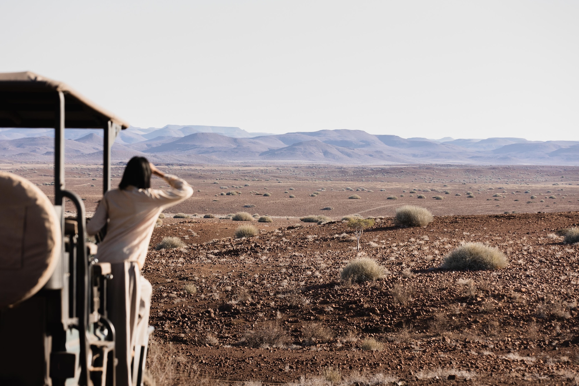 A guest on a game drive looks into the distance while on a Namibia safari in Damaraland
