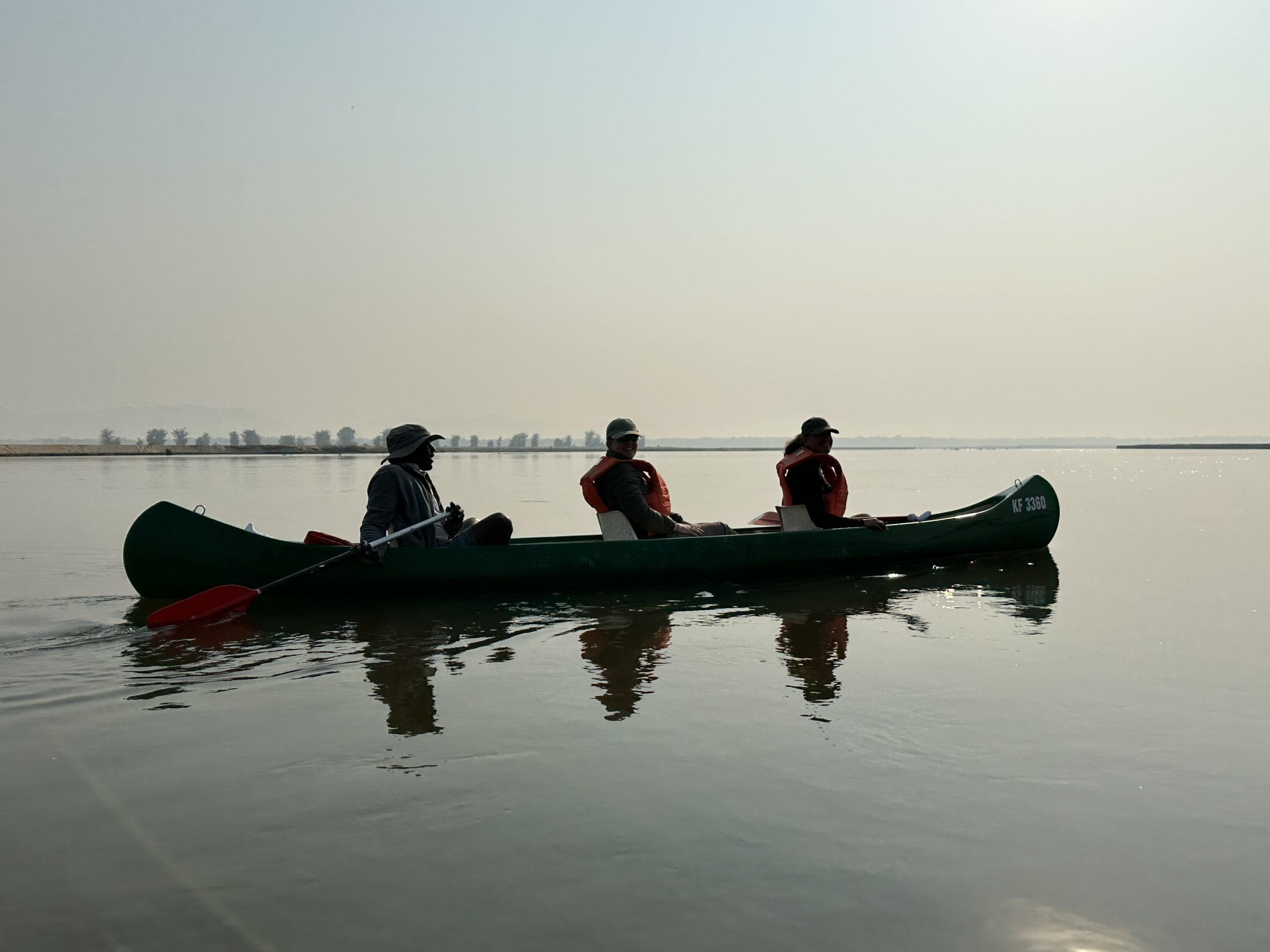 Canoe safari on calm Zimbabwean waters, offering a low, close-to-nature wildlife perspective.